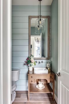 a bathroom with blue walls and wood floors