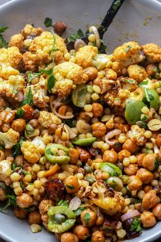 a white bowl filled with corn and vegetables