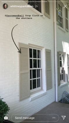 a white brick house with shutters open and an arrow pointing to the left side