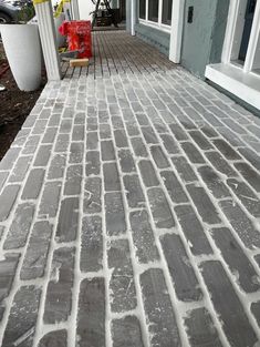 a brick walkway is being laid in front of a house with a red fire hydrant