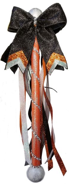 a tall orange and black pole with ribbons on it's end, decorated with glitters