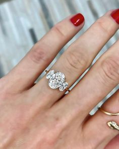 a woman's hand with three different rings on it and one has a red manicure