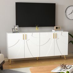 a living room with a large flat screen tv on top of a white entertainment center