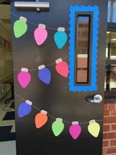 a door decorated with christmas decorations and lights on a string in front of a brick building