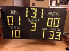 a person holding up a score board with numbers on it