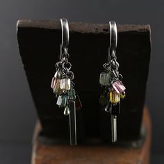 Unique and beautiful handmade 925 silver earrings with raw multi-colour tourmaline beads. Measurements: Total length - approx. 2 inch (5 cm) Tourmaline bead size - approx. 0.1 x 0.2 inch (3 x 5 mm) Sterling silver bar - approx. 0.1 x 0.8 inch (2.7 x 21 mm) Sterling silver drops - approx. 0.1 x 0.2 inch (3 x 5 mm) Postage & Packaging: United Kingdom: Royal Mail 1st class Delivery time: usually 1-2 working days Worldwide: International Standard  Delivery time: 7-9 working days The earrings will be packaged in an elegant jewellery box. Please note that due to the nature of stones, each one may vary slightly in colour, shape or size. Every piece of jewellery is unique and one of a kind. Therefore the earrings you will receive will contain very similar but not exact the same stones as in the ph Modern Silver Earrings, Rustic Bracelet, Organic Jewelry, Tourmaline Earrings, Sterling Silver Charm Bracelet, Silver Bar, Tourmaline Beads, Earrings Simple, Silver Dangle Earrings