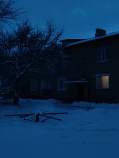 a house in the dark with snow on the ground