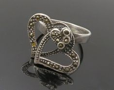 925 Sterling Silver - Vintage Marcasite Open Love Heart Band Ring Sz 7 - RG15152  925 Sterling Silver - Vintage Marcasite Open Love Heart Band Ring Sz 7 - RG15152  Jewelry Type:         Ring  Metal Type:            925 Silver  Metal Size:             7 Finger  Stone Type:            Marcasite   Condition:              N/A  Jewelry Weight:     4.5 Grams  PLEASE NOTE: THIS ITEM IS PRE-OWNED. ALTHOUGH MOST ITEMS ARE IN VERY GOOD CONDITION, SOME MAY NEED CLEANING AND/OR MINOR REPAIRS. WE MAKE A VERY STRONG EFFORT TO UPLOAD CLEAR PICTURES. PLEASE INSPECT ALL PICTURES AND ASK ALL QUESTIONS YOU MAY HAVE PRIOR TO MAKING A PURCHASE. NOT ALL STONES ARE GENUINE, SOME ARE ENHANCED OR CREATED. Heart Band, Ring Metal, Fun Earrings, Antique Rings, Band Ring, Band Rings, Metallic Silver, Etsy Gifts, Sell On Etsy