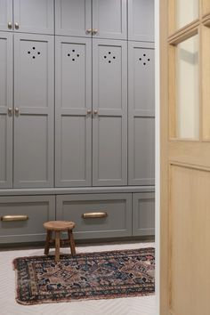 a room with gray cupboards and a rug on the floor in front of it