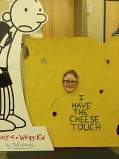 a child's face is peeking out from a cardboard sign that says i have the cheese touch