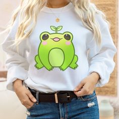 PLEASE NOTE:  This is a UNISEX sweater.  If you want an oversized look then consider ordering up a size. This cute froggie frog sweater will look adorable on you!  Makes for a great kawaii gift to give to your friends as well. The collar is ribbed knit, so it retains its shape even after washing. There are no itchy side seams on these sweaters.  .: 50% cotton, 50% polyester .: Medium-heavy fabric (8.0 oz/yd² (271.25 g/m .: Loose fit .: Sewn-in label .: Runs true to size Frog Sweater, Cute Kawaii Clothes, Frog Sweatshirt, Gifts For Teenage Girls, Cottagecore Sweater, 1970s Clothing, Cow Costume, Harajuku Sweatshirt, Sweatshirt Oversized