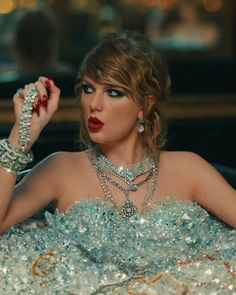 a woman with red lipstick and jewelry sitting in a chair