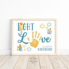 a framed poster with the words light and love written in blue on it, next to a wooden floor