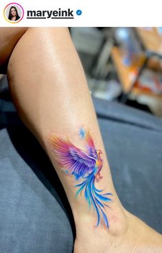 a woman's foot with a colorful bird tattoo on it