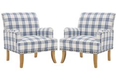 a pair of blue and white checkered chairs with buttons on the arms, facing each other