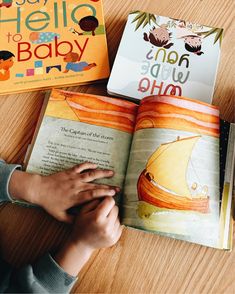 two children's books sitting on top of a wooden table