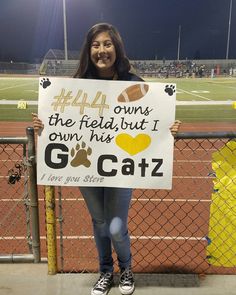 a girl holding up a sign that says, the field but i own my catz