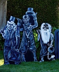 three painted tombstones in the shape of wizard's and witches