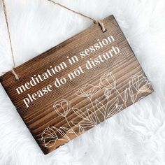 a wooden sign that says, with a client please have a seat on it hanging from a string