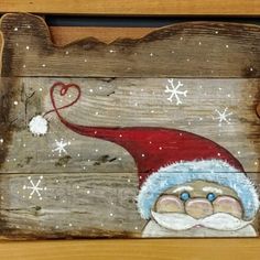 a wooden sign with santa clause painted on it