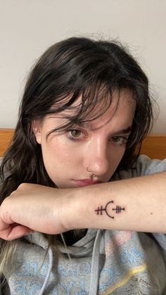 a woman with a cross tattoo on her arm