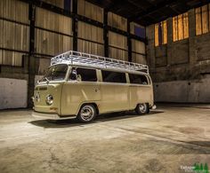 an old vw bus is parked in a garage with its roof rack on top