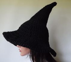 a woman wearing a black crocheted witches hat