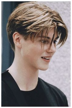 a young man with short hair wearing a black shirt