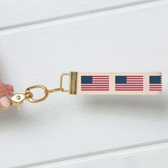 a hand holding a key chain with an american flag on it