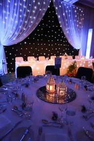 the table is set with silverware, candles and white linens for a formal function