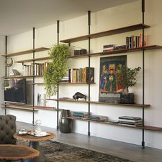 a living room filled with furniture and bookshelves next to a wall mounted tv