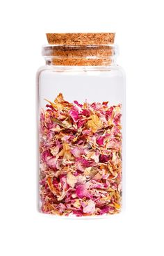 a jar filled with dried flowers on top of a white surface