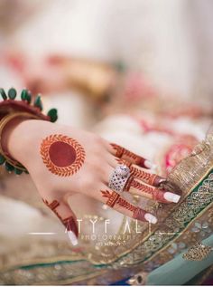 a woman's hand with henna on it and some jewelry around her wrist