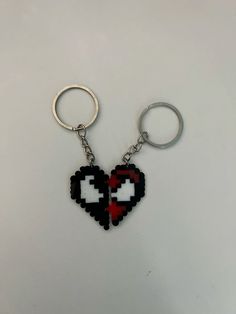 a heart shaped keychain with two pixeles in it on a white surface