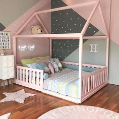 a child's bedroom with pink and grey walls, wooden flooring and a white bed