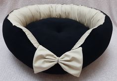 a black and white dog bed with a bow tie on it's front end