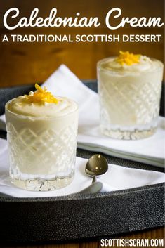 two small desserts with white frosting and orange zest on top, sitting on a tray