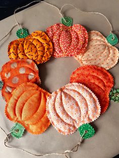 an assortment of fabric pumpkins are arranged on a platter with twine string