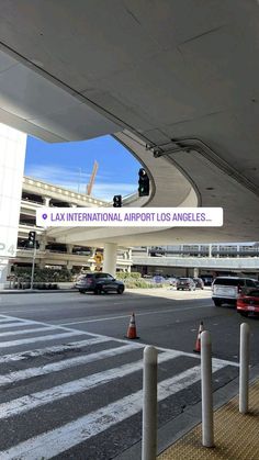 an airport with cars parked on the side of the road and traffic lights in front of it