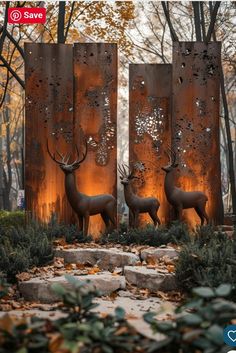 three deer sculptures in the middle of a park with trees and leaves around them, surrounded by foliage