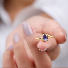 Product Details Introducing the stunning Minimal Teardrop Tanzanite Ring, featuring a 5x7 mm Tanzanite stone in a Prong Setting on a Bypass Shank. This exquisite Tanzanite Solitaire Ring is sure to make a statement and be the ultimate choice for your beloved partner. Product Information SKU SHP-RINGS0821162053 Width 2.9 mm Height 6.4 mm Weight 1.92 gm (Approximate) TANZANITE INFORMATION No.of Stones 1 Pieces Total Weight 0.84 Carat (Approximate) Dimension(approx) Pear-5X7 mm-1 Pcs Color Blue Cut Tanzanite Solitaire Ring, Bypass Engagement Ring, Pear Cut Ring, Tanzanite Stone, Jewelry Accessories Ideas, Tanzanite Ring, Tanzanite Gemstone, Signature Jewelry, Finger Rings