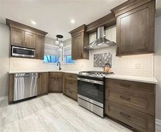 a large kitchen with wooden cabinets and stainless steel stove top oven, dishwasher and microwave