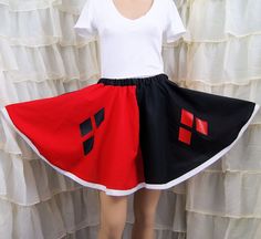 a woman wearing a red and black skirt standing next to a white curtain in front of a window