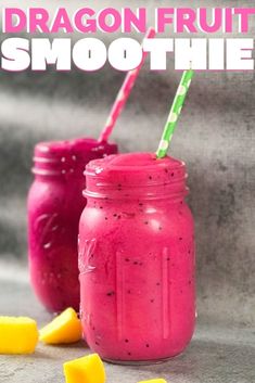 two mason jars filled with fruit smoothie next to slices of lemon