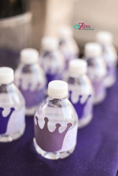 there are many water bottles with purple designs on the top and one has a white cap