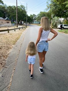 a mother and daughter walking down the street