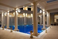 an indoor swimming pool surrounded by columns and lights