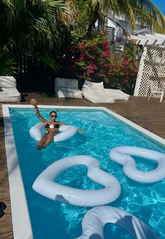 a woman floating on an inflatable raft next to a swimming pool