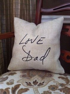 a pillow with the words love dad written on it sitting on top of a chair