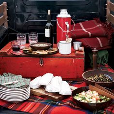 a picnic table with food and drinks on it in front of an open fire place